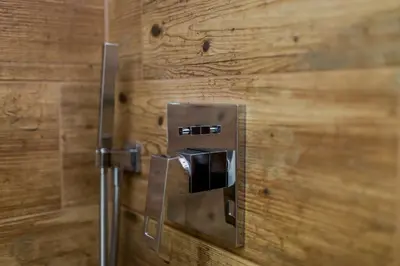 a toilet paper dispenser on a wooden wall at Kings Landing Apartament in Kraków