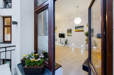 a living room with a hallway with flowers in a room at Kings Landing Apartament in Kraków