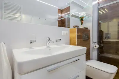 a white bathroom with a sink and a toilet at Kings Landing Apartament in Kraków