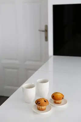 two muffins and two cups on a white table at Elegant City Center Zyblikiewicza 165 in Kraków