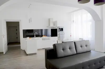 a living room with a couch and a kitchen at Elegant City Center Zyblikiewicza 165 in Kraków