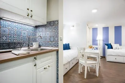 a kitchen with a sink and a bedroom with a bed at P&J Luxury Apartments in Kraków