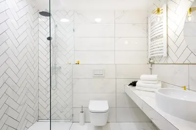 a white bathroom with a toilet and a sink at P&J Luxury Apartments in Kraków