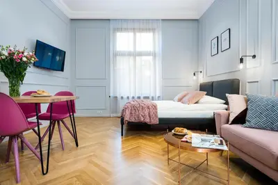 a living room with a bed and a table at P&J Luxury Apartments in Kraków
