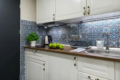 a kitchen with white cabinets and a sink at P&J Luxury Apartments in Kraków