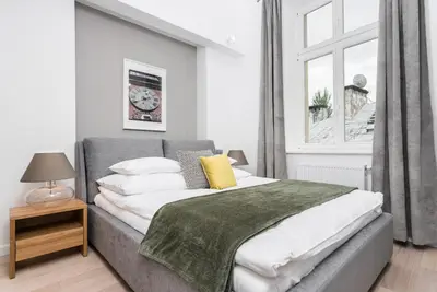 a bedroom with a bed and a table and chairs at Venetian House Market Square Aparthotel in Kraków