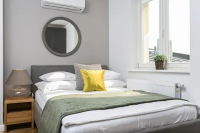 a bedroom with a bed and a table and chairs at Venetian House Market Square Aparthotel in Kraków