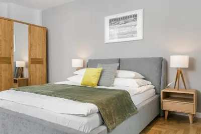 a bedroom with a bed and a table and a desk at Venetian House Market Square Aparthotel in Kraków