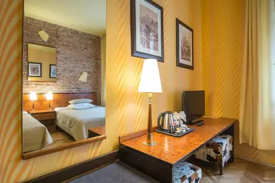 a hotel room with a bed and a mirror at Finger Guest Rooms in Kraków