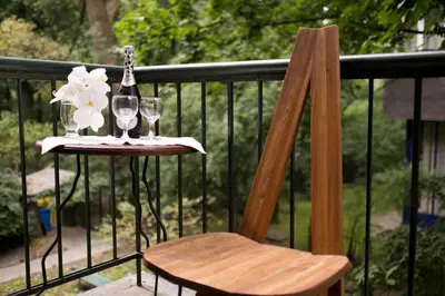 a wooden chair and a table with a bottle and glasses at Finger Guest Rooms in Kraków