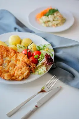 two plates of food on a table with a fork at Hotel Grand Felix in Kraków