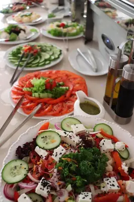a table full of plates of food with vegetables at Hotel Grand Felix in Kraków