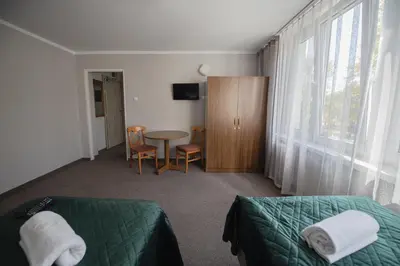a bedroom with a bed and a table and a window at Hotel Felix in Kraków