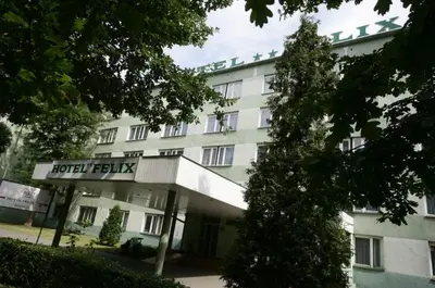 a large white building with a sign in front of it at Hotel Felix in Kraków