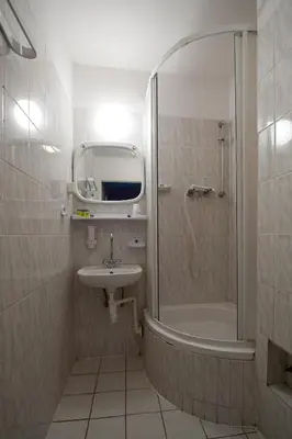 a small bathroom with a shower and a sink at Hotel Felix in Kraków