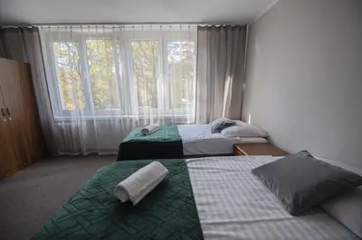 two beds in a room with a window at Hotel Felix in Kraków