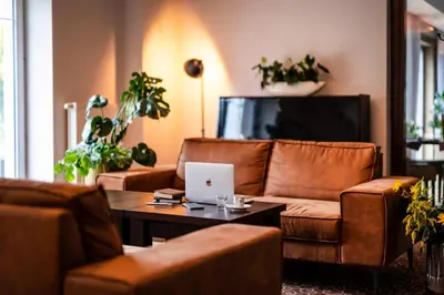 a living room with a couch and a laptop on a table at Dosłońce Resort Wellness & Farm in Racławice