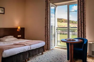 a hotel room with a bed and a large window at Dosłońce Resort Wellness & Farm in Racławice