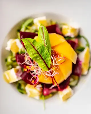 a white bowl filled with a salad with fruit and vegetables at Dosłońce Resort Wellness & Farm in Racławice