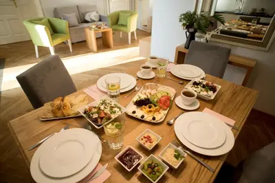 a wooden table with plates and food on it at Belle Epoque Residence in Kraków