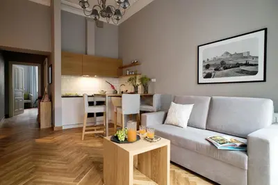 a living room with a couch and a kitchen at Belle Epoque Residence in Kraków
