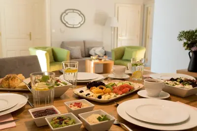 a table with plates and bowls of food on it at Belle Epoque Residence in Kraków