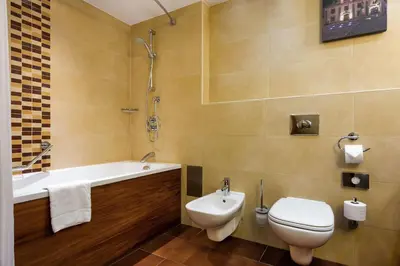 a bathroom with a toilet and a tub and a sink at Hilton Garden Inn Krakow in Kraków