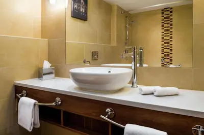 a bathroom with a bowl sink and a mirror at Hilton Garden Inn Krakow in Kraków