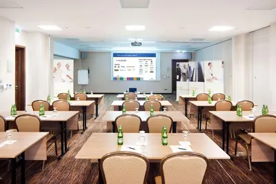 a classroom with tables and chairs and a projection screen at Hilton Garden Inn Krakow in Kraków