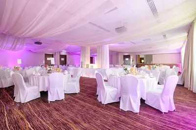a banquet hall with white tables and chairs at Hilton Garden Inn Krakow in Kraków