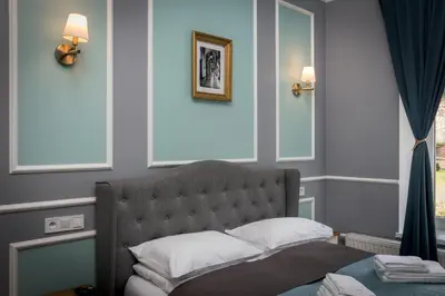 a bedroom with a bed and two windows and a mirror at Domles Apartments in Kraków