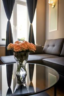 a vase filled with orange roses sitting on a table at Domles Apartments in Kraków