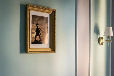 a picture of a man hanging on a wall at Domles Apartments in Kraków