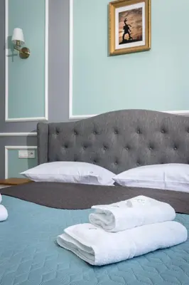 a bedroom with a bed with towels on it at Domles Apartments in Kraków