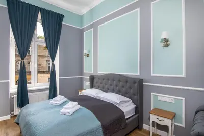 a bedroom with a bed and a window at Domles Apartments in Kraków
