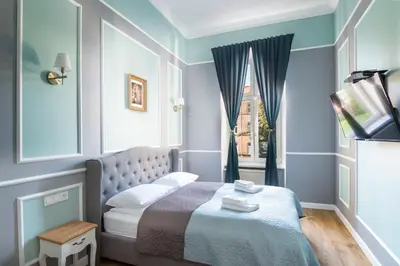 a small bedroom with a bed and a window at Domles Apartments in Kraków
