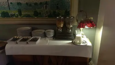 a table with a candle and plates and a lamp at Hotel Alef in Kraków