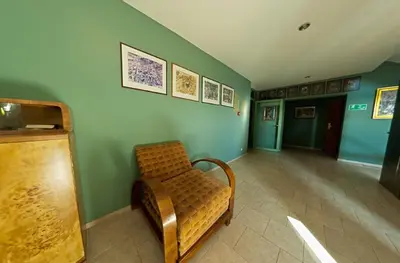 a waiting room with a bench in a room with green walls at Hotel Alef in Kraków