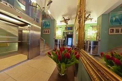 a vase of red tulips sitting on a table next to a mirror at Hotel Alef in Kraków