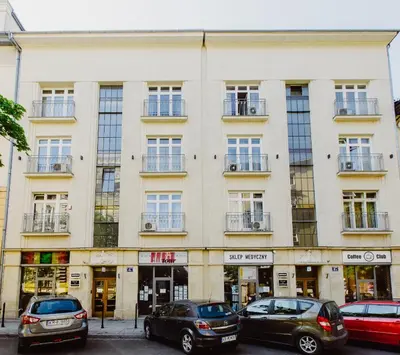 a large white building with cars parked in front of it at 4Seasons﻿ Apartments Cracow in Kraków