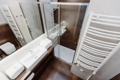 a bathroom with a shower and a sink and a mirror at 4Seasons﻿ Apartments Cracow in Kraków