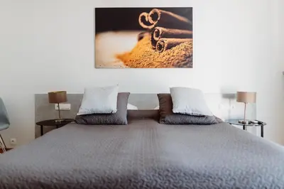 a bedroom with a bed with a picture on the wall at 4Seasons﻿ Apartments Cracow in Kraków