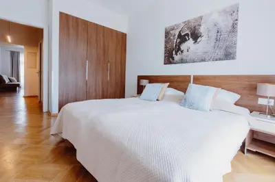 a bedroom with a large white bed with a wooden headboard at 4Seasons﻿ Apartments Cracow in Kraków