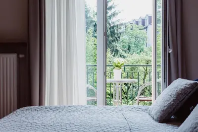 a bedroom with a bed and a large window at 4Seasons﻿ Apartments Cracow in Kraków