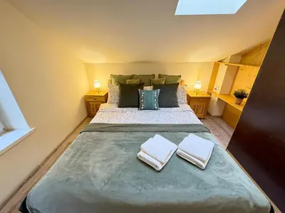 a bedroom with a large bed with two towels on it at Przystanek Rabka - Domek całoroczny in Rabka