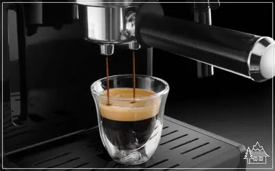 a coffee machine is making a drink in a cup at Przystanek Rabka - Domek całoroczny in Rabka