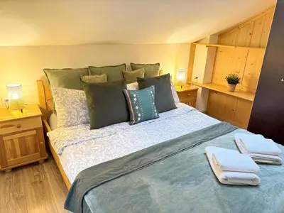 a bedroom with a large bed with two towels on it at Przystanek Rabka - Domek całoroczny in Rabka