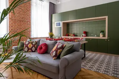a living room with a gray couch with colorful pillows at Kokon Old Town in Kraków