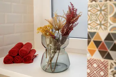a vase with flowers and red roses on a counter at Kokon Old Town in Kraków