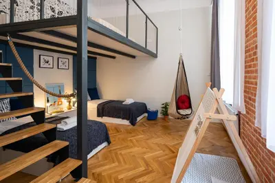 a room with a loft with a bed and a staircase at Kokon Old Town in Kraków